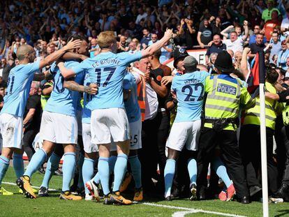 Los jugadores del City celebran entre la afición y la policía.