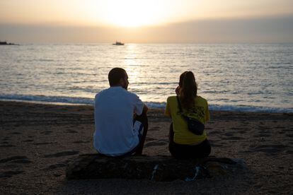 Una pareja observa el mar en una playa de Barcelona.