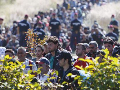 Polic&iacute;as h&uacute;ngaros vigilan a refugiados en la frontera con Croacia.