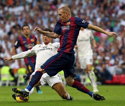 El defensa francés del FC Barcelona Jeremy MAthieu controla el balón ante el delantero portugués del Real Madrid Cristiano Ronaldo.