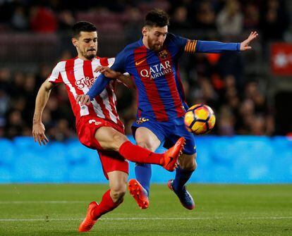 Lionel Messi (derecha) pelea por el balón frente a Sergio Álvarez del Sporting de Gijón.