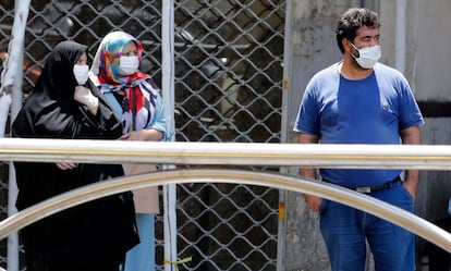 Dos mujeres y un hombre con mascarilla en Teherán, capital de Irán.