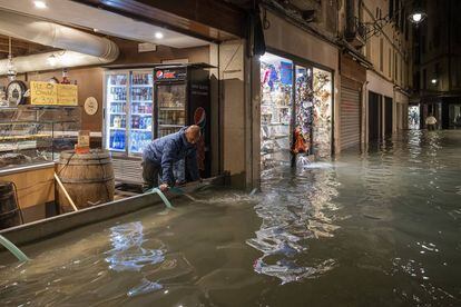 Un hombre de 78 años que se electrocutó en su casa en la isla de Pellestrina, al sur de Venecia, debido a un cortocircuito. En la imagen, un trabajador de un establecimiento achica agua durante las inundaciones, el martes por la noche.