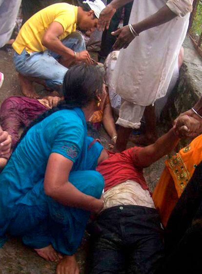 La gente trata de trasladar a los fallecidos por una estampida en un templo hindú en India