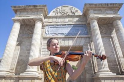 La violinista eslovena Klara Gomboc tocando delante de la puerta del Puente.