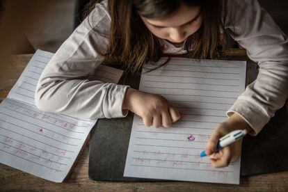 Una niña zurda escribe en un cuaderno