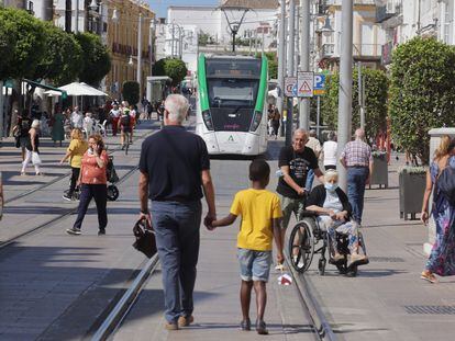 El tranvía en pruebas pasa por la Calle Real de San Fernando, Cádiz compartiendo la avenida con el tránsito de peatones y coches autorizados, aún en su fase de pruebas en blanco