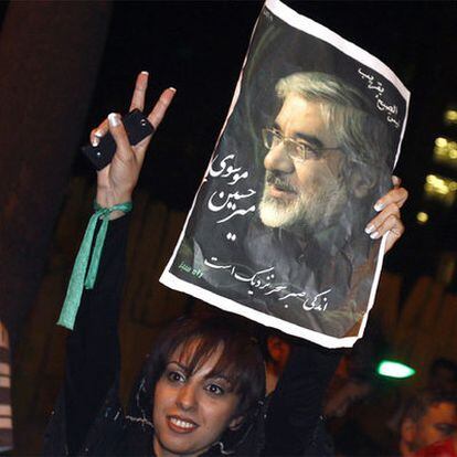 Una de las seguidoras del Musavi muestra un cartel del candidato en las calles de Teheran