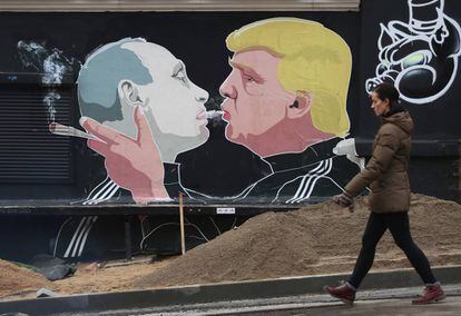 Una mujer, junto a un mural con la imagen de Trump y Putin en Vilna, Lituania.