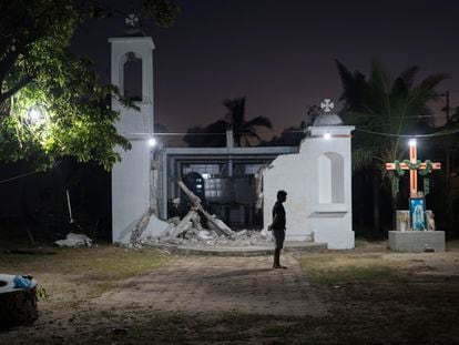 Un joven frente a una capilla destruida por el huracán Otis, en diciembre de 2023.