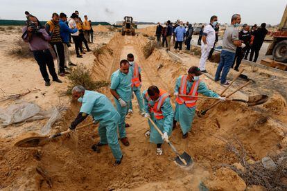 Varios hombres cavan una fosa común para enterrar los cuerpos de las víctimas de los ataques israelíes, que fueron transportadas desde el hospital Al Shifa, en la ciudad de Gaza, para ser enterrados en Jan Yunis, al sur de la Franja. 