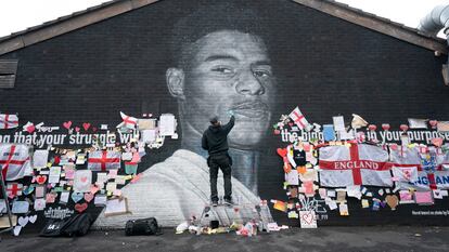 El grafitero Akse P19 repara el mural dedicado en Manchester al futbolista Marcus Rashford, después de que fuera dañado tras su fallo en los penaltis de la Eurocopa.