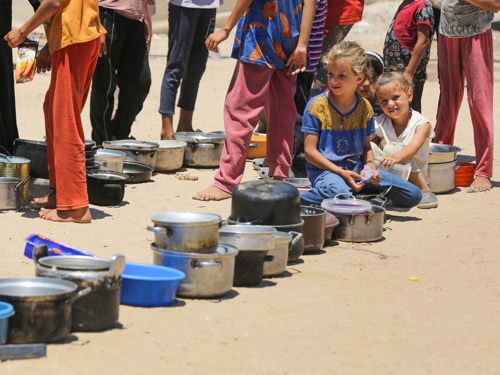 Varios menores esperan en la cola para recibir alimentos, el domingo en Deir al Balah, en Gaza.
