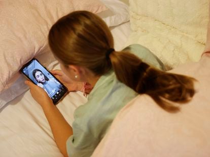Una adolescente observa a una influencer en TikTok en su teléfono móvil.