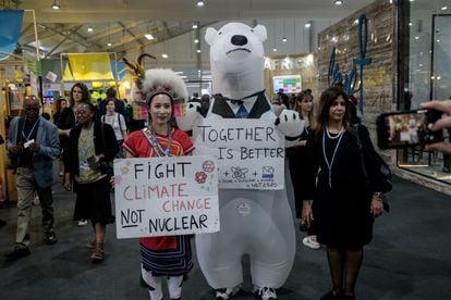 Dos activistas disfrazados y con pancartas dentro del Centro Internacional de Congresos, durante la conferencia de las Naciones Unidas sobre el cambio climático, el día 9.