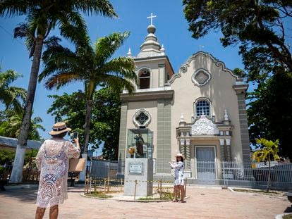 Dos mujeres toman fotografías a las afueras de una iglesia en Alagoas (Brasil), el pasado 23 de enero.