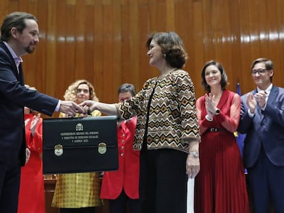 El nuevo Vicepresidente de Derechos Sociales y Agenda 2030, Pablo Iglesias (i) recibe su cartera de la vicepresidenta primera y ministra de Presidencia y Relaciones con las Cortes, Carmen Calvo (d) durante la toma de posesión en un acto celebrado en la sede del Ministerio de Sanidad, Consumo y Bienestar Social en Madrid.