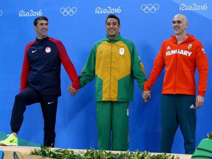 Michael Phelps (i), Chad le Clos (c) y Laszlo Cseh, medallistas de plata en 100m mariposa.