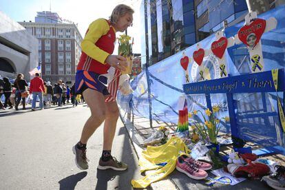 Un atleta rinde homenaje a las víctimas de los atentados de 2013 en un improvisasdo monumento en la línea de meta desde donde saldrán los participantes en el maratón de este año.