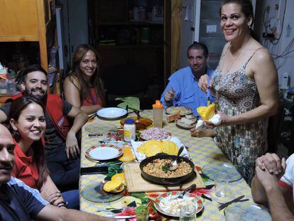 La venezolana María Lezama (de pie), prepara arepas para los compatriotas emigrados que se alojan en el hostel Mamá Carmen, en Iguazú.