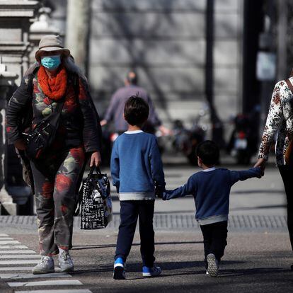 GRAF5434. MADRID, 11/03/2020.- Un par de niños cruzan una calle este miércoles, en Madrid. La Comunidad de Madrid suspendió las clases durante quince días, a partir de hoy, para intentar contener la epidemia del coronavirus. El Ministerio de Sanidad ha confirmado este miércoles 2.002 casos de coronavirus en España (363 más que ayer) y 47 fallecidos (once más), y casi la mitad de ellos -tanto los contagios como las muertes- se han dado en la Comunidad de Madrid. EFE/ Juan Carlos Hidalgo