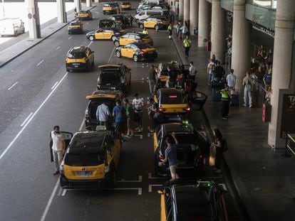 Taxistas recogen a clientes en el aeropuerto de El Prat de Barcelona, este jueves.