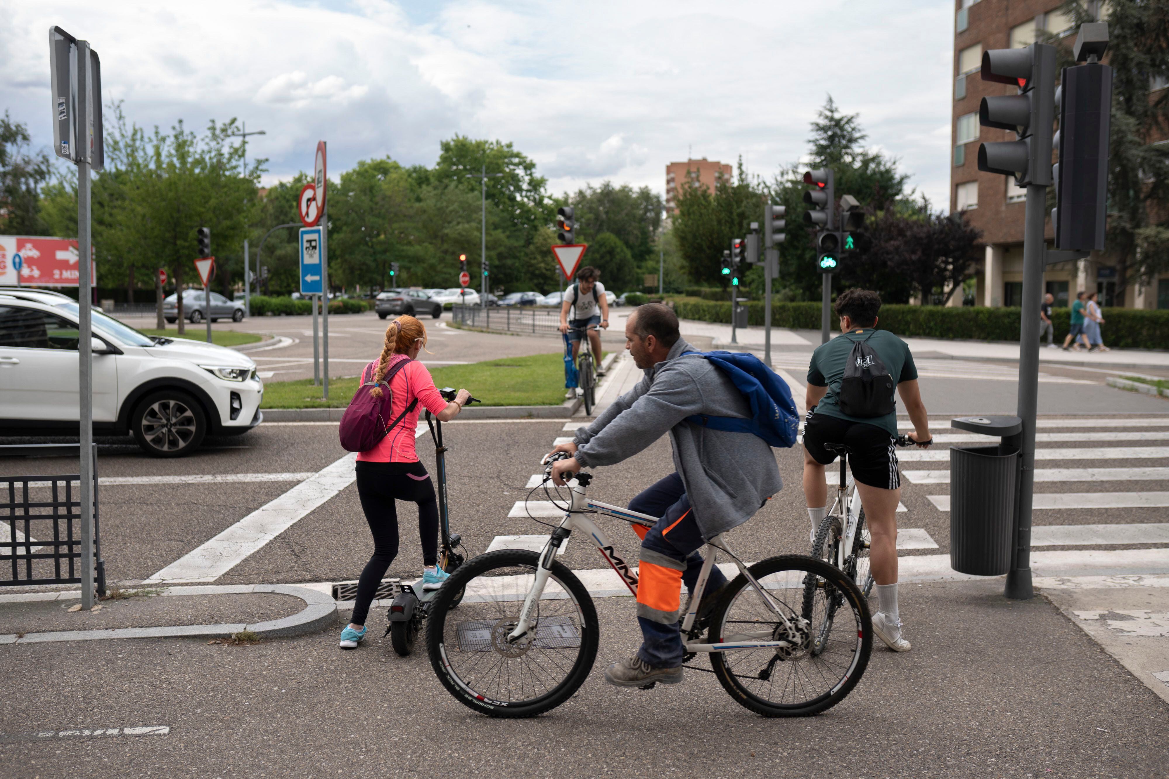 Usuarios de bicicleta y patinete en el carril que da acceso al puente de Poniente, en Valladolid.