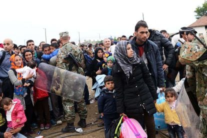 Decenas de refugiados esperan en la frontera entre Grecia y Macedonia, este domingo.