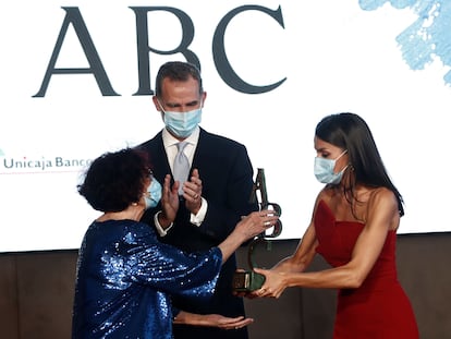 Maruja Torres recoge el premio Luca de Tena de manos de la reina Letizia mientras apalude el Rey.