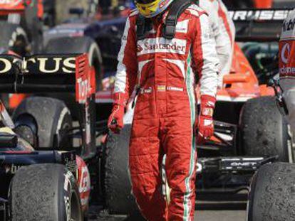 Fernando Alonso observa el estado de los neum&aacute;ticos tras concluir la conclusi&oacute;n del GP de Hungr&iacute;a