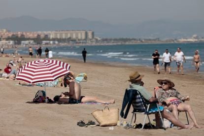 Gente tomando el sol en la playa de la Malvarrosa de Valencia, donde los termómetros rozan los 30 grados, este lunes.
