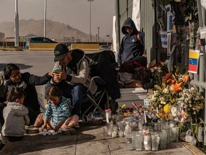 Una familia de migrantes venezolanos cuida el altar dedicado a las víctimas del incendio del Instituto Nacional de Migración, en Ciudad Juárez.