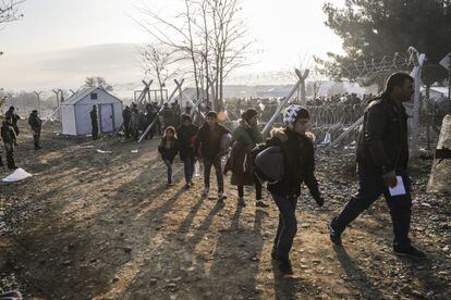Una familia de inmigrantes camina hacia un campo de registro después de entrar en Macedonia desde Grecia.