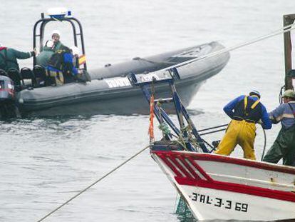 Agentes de la Guardia Civil, junto a un pesquero de la bah&iacute;a de Algeciras.