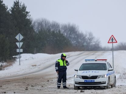 Una patrulla policial vigila la carretera que lleva al lugar donde fue derribado un avión militar el miércoles, cerca de Yablonovo, en la región rusa de Bélgorod.