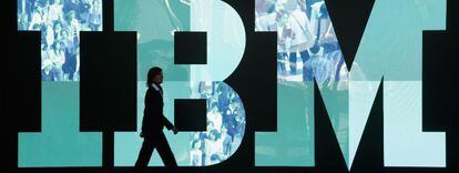 Una mujer pasa por delante del logo de IBM.
