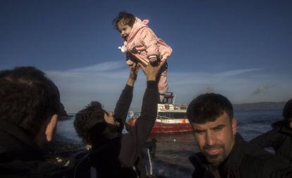 Un iraquí, procedente de la ciudad de Mosul (ocupada por el ISIS), sostiene a su hija tras llegar en un pequeño bote, junto a otros 150 refugiados, a la isla de Lesbos este martes.