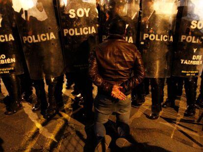 Un seguidor de Guillermo Lasso, frente a la polic&iacute;a ecuatoriana.