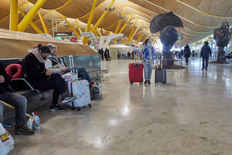 Varios pasajeros esperan en la Terminal 4 del aeropuerto Madrid-Barajas Adolfo Suárez.