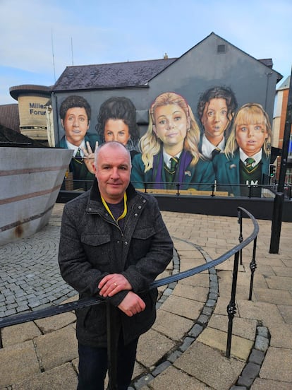 Gleann Doherty, frente al mural de Las Derry Girls, en el centro de la ciudad de Derry.