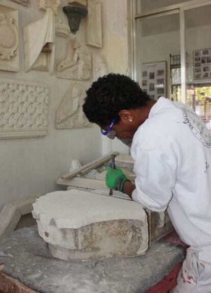 Un inmigrante en un taller de escultura en piedra.