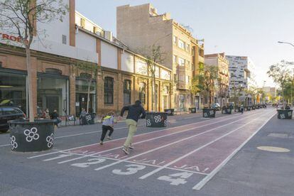 El carrer d'Almogàvers, a la superilla del Poblenou. Les cruïlles s'han convertit en quatre places i d'un carrer a l'altre s'han ubicat elements lúdics o bancs amb taules.