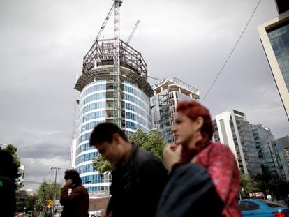 La gente pasa frente a un edificio en construcción en la Ciudad de México, México.