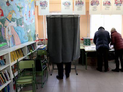 Varios electores escogen su papeleta en el colegio público La Navata, en Galapagar.