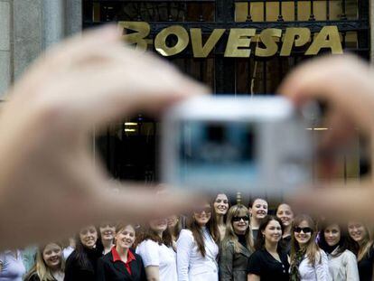 Una persona fotograf&iacute;a toma un foto de grupo ante la fachada de la Bolsa de S&atilde;o Paulo (Brasil).