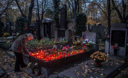 Una dona encén espelmes al cementiri Olsany de Praga, el dia de Tots Sants (1 de novembre).