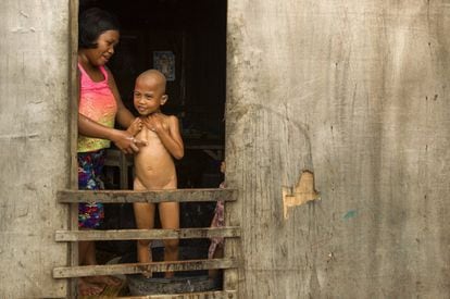 Una vecina de Anibong bañando a su hijo.