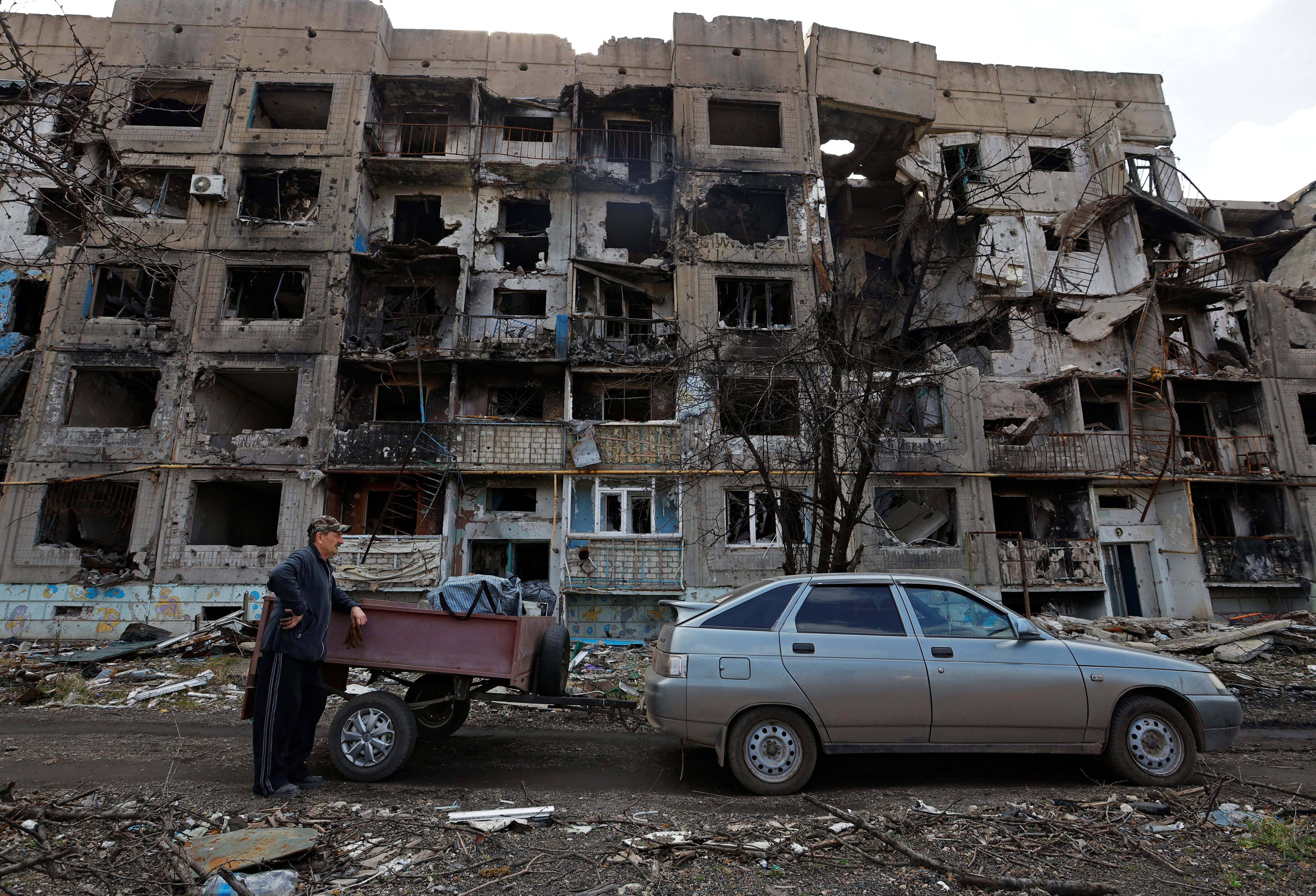 Un vecino junto a un automóvil frente a un edificio gravemente dañado en el asentamiento de Toshkivka (Lugansk) este domingo.