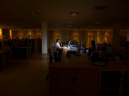 Una mujer trabaja en una oficina sin luz natural.