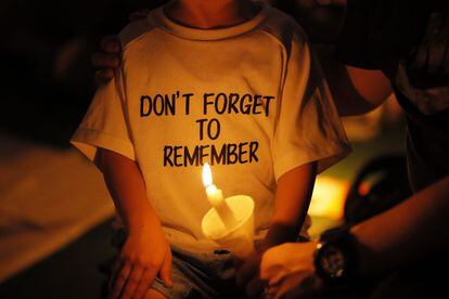 Un niño lleva una camiseta en la que se puede leer en inglés "No olvides recordar", durante una vigilia por las víctimas de la represión militar del gobierno chino en Tiananmen, cuando se cumplen tres décadas de la masacre, en parque Victoria (Hong Kong). 